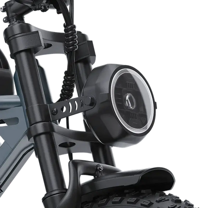 Close-up of electric scooter front suspension and round LED headlight with black frame and thick tire