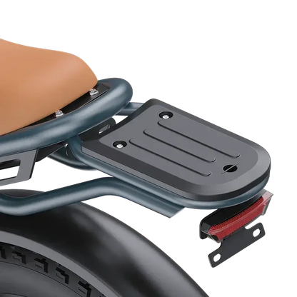 Close-up of black metal rear luggage rack with four mounting holes on electric scooter seat